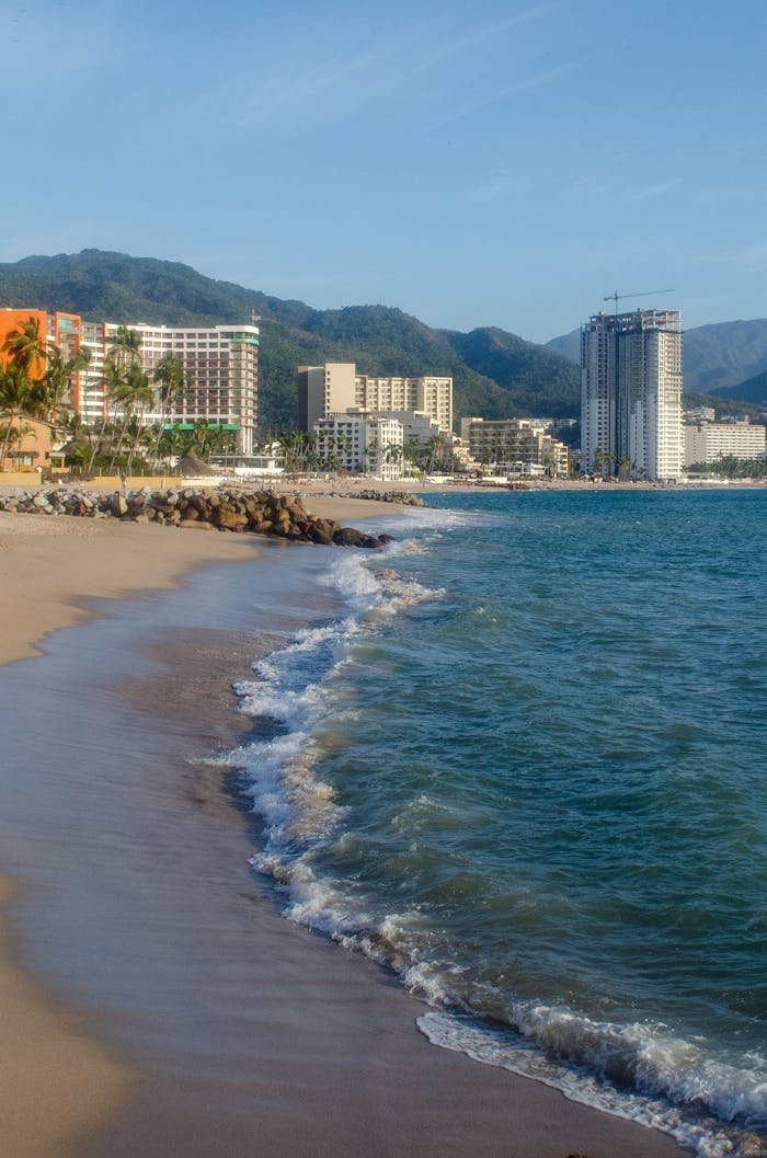 Idyllic beach scene in Puerto Vallarta with urban high-rises and ocean waves.